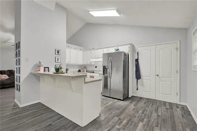 a kitchen with a sink refrigerator and cabinets