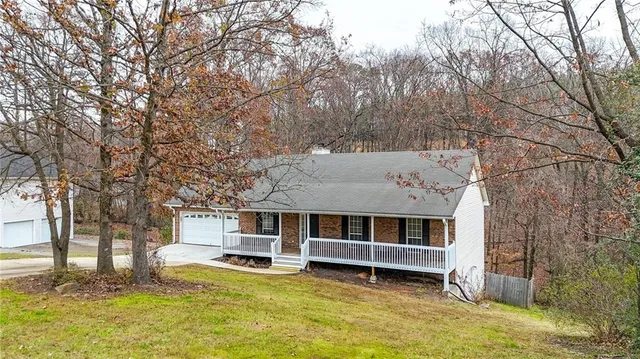 a view of a house with a big yard and large tree