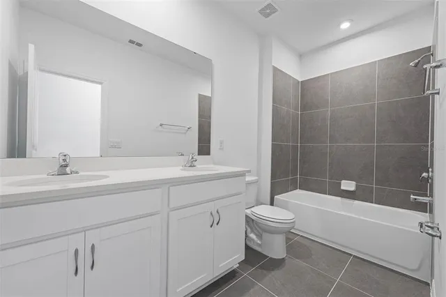 a bathroom with a double vanity sink toilet and shower