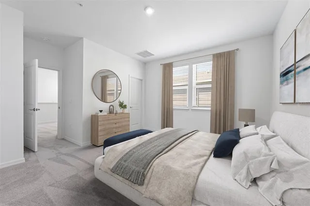 a bedroom with a bed a mirror and a window