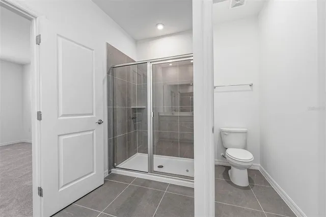 a bathroom with a toilet and a shower