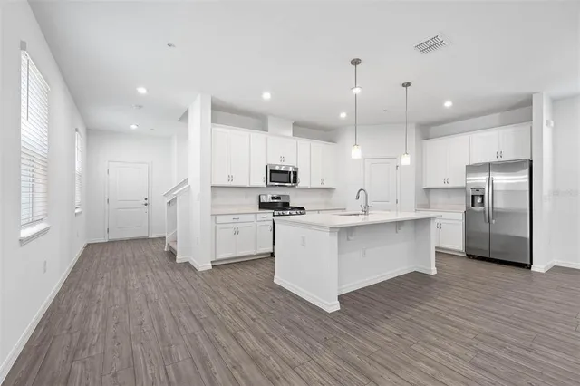 a kitchen with white cabinets stainless steel appliances