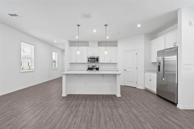 a view of kitchen with wooden floor and refrigerator