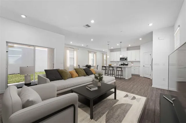 a living room with furniture and kitchen view