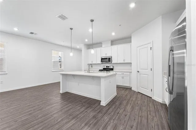 a kitchen with white cabinets and stainless steel appliances