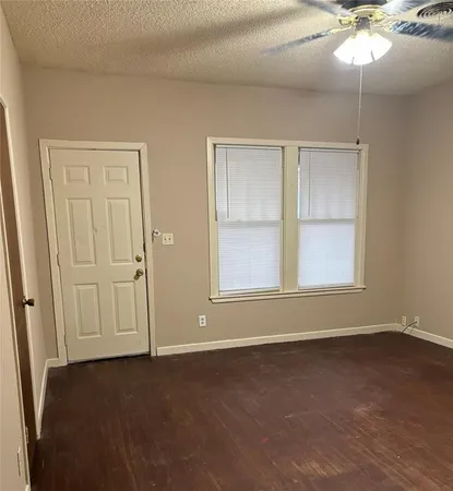 an empty room with fan and windows