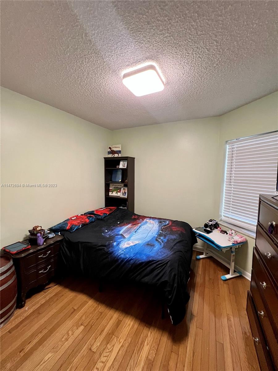 West End Miami, FL 33185 - Photo 17 of 30 a bedroom with a bed and a wooden floor