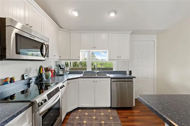 a kitchen with stainless steel appliances a sink stove and cabinets
