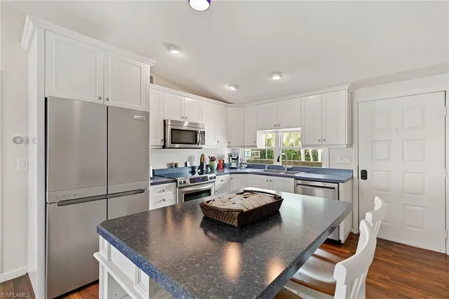 a kitchen with sink refrigerator and microwave