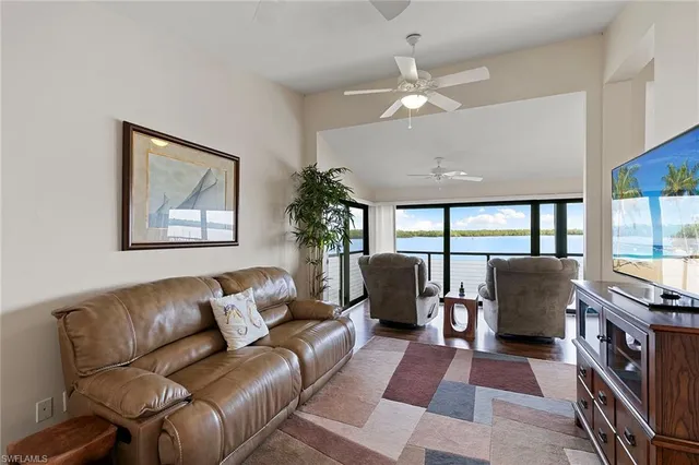 a living room with furniture a large window and a flat screen tv
