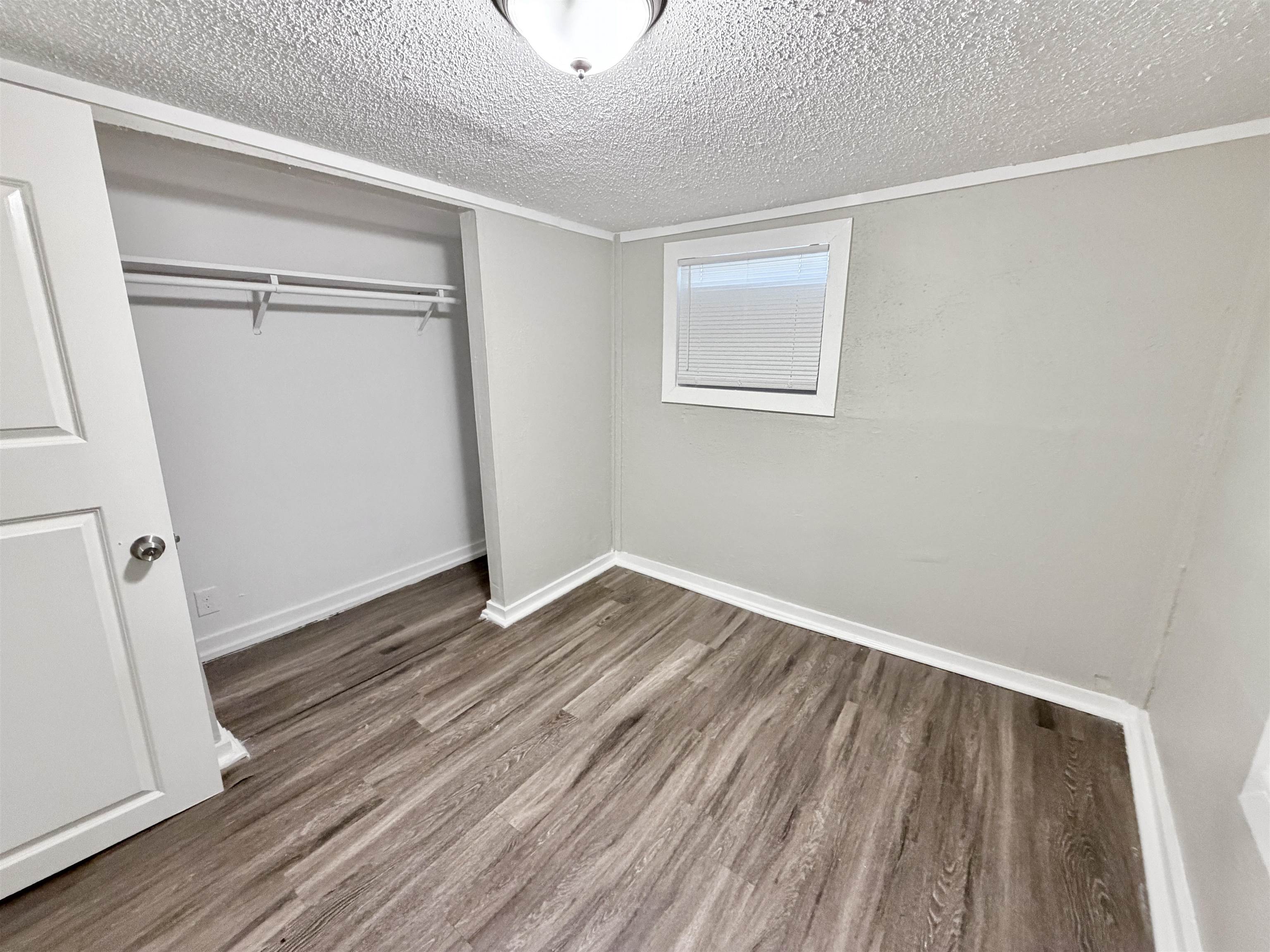 3100 Travis Road Memphis, TN 38109 - Photo 11 of 16 Wood-finish flooring, white trim, recessed window with blinds, and built-in closet shelving
