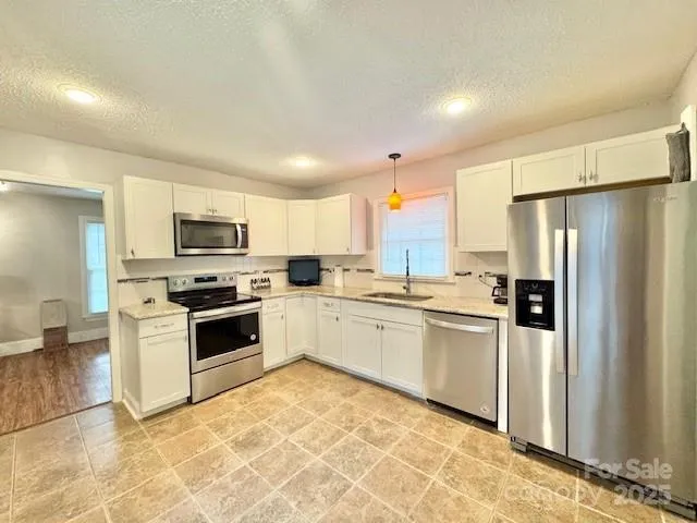 a kitchen with stainless steel appliances granite countertop a refrigerator sink and stove