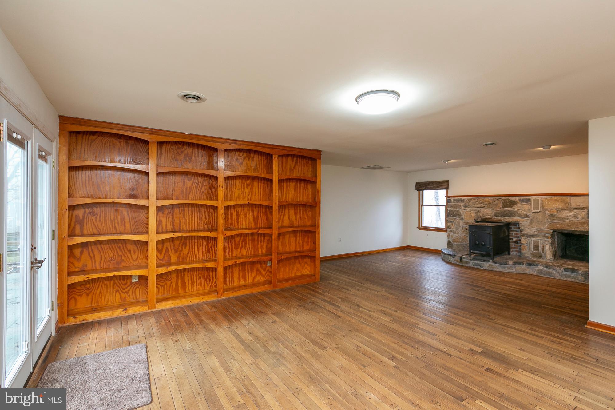 35 Grant Road Kearneysville, WV 25430 - Photo 19 of 122 a view of an empty room with wooden floor fire place and windows