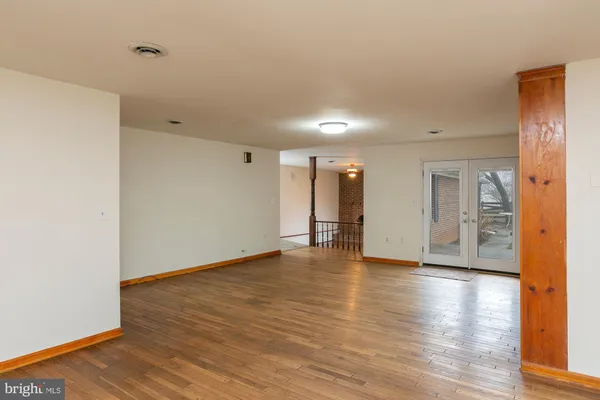 a view of a room with a ceiling fan and wooden floor