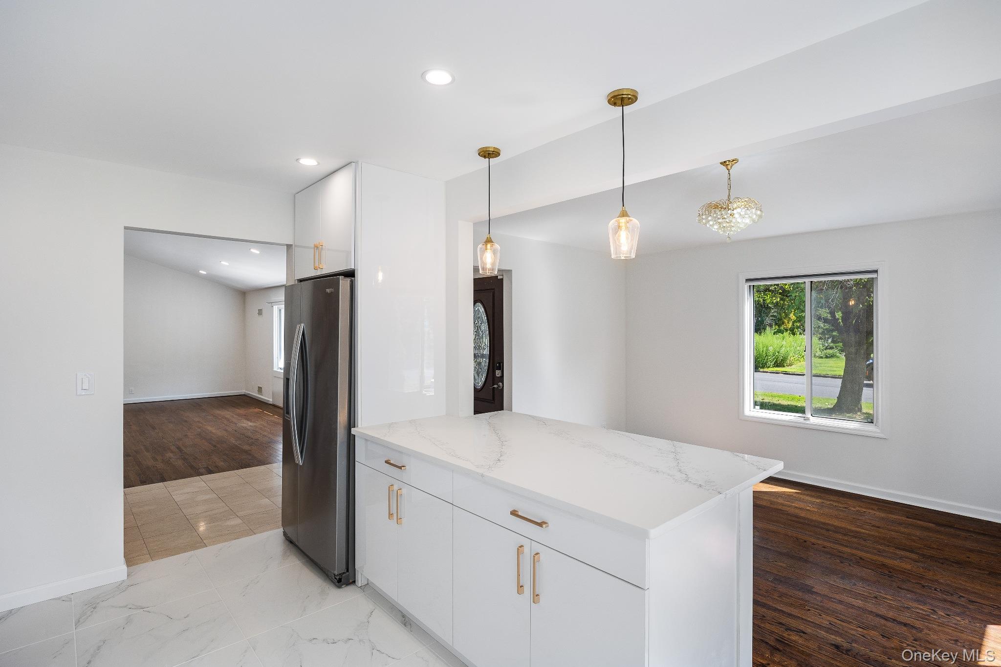 372 Heathcote Road Scarsdale, NY 10583 - Photo 6 of 20 Kitchen featuring white cabinets, hanging light fixtures, stainless steel fridge with ice dispenser, light stone counters, and recessed lighting