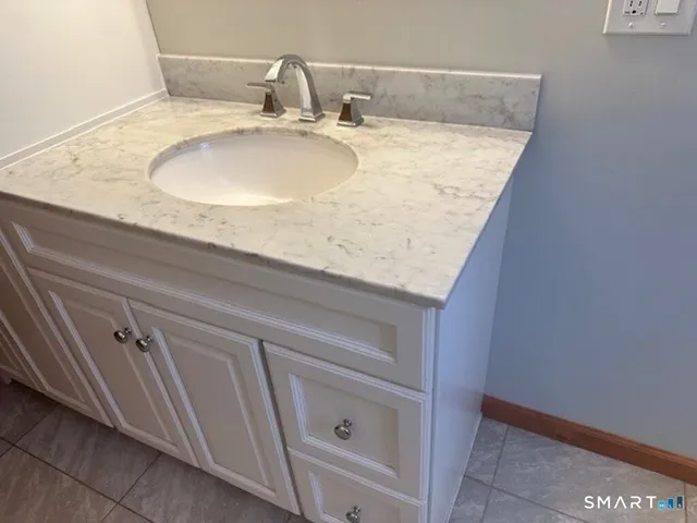 a bathroom with a granite countertop sink and vanity