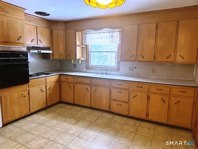 a kitchen with cabinets appliances and a window