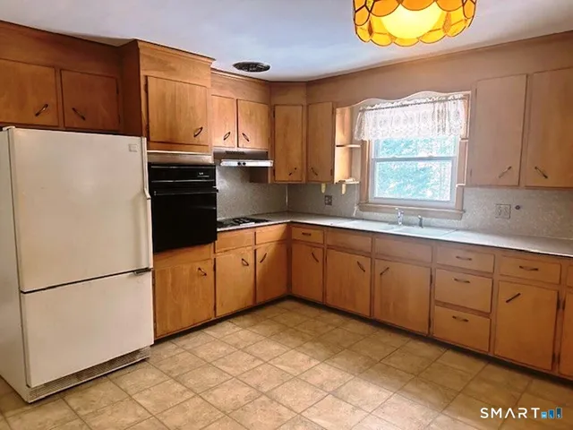 a kitchen with stainless steel appliances granite countertop a refrigerator sink and cabinets