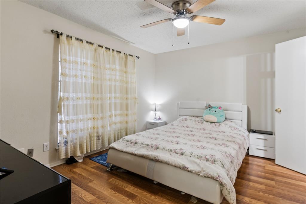 11311 Audelia Road, Unit 102 Dallas, TX 75243 - Photo 20 of 31 Wood-finish flooring, ceiling fan with integrated lighting, and a window with sheer drapes