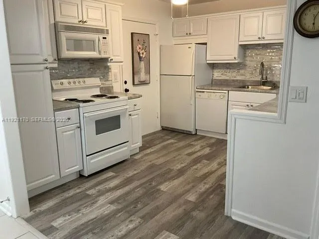 a kitchen with a stove a refrigerator and a sink