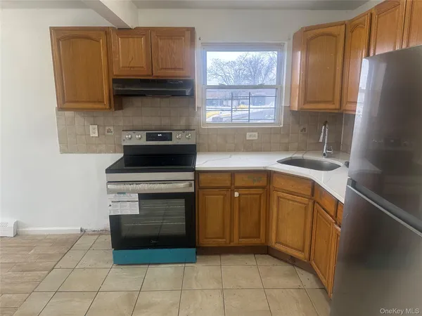 a kitchen with granite countertop a stove a sink and a refrigerator