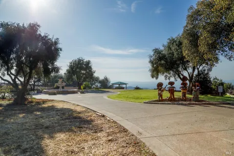a view of swimming pool with outdoor seating and trees in the background