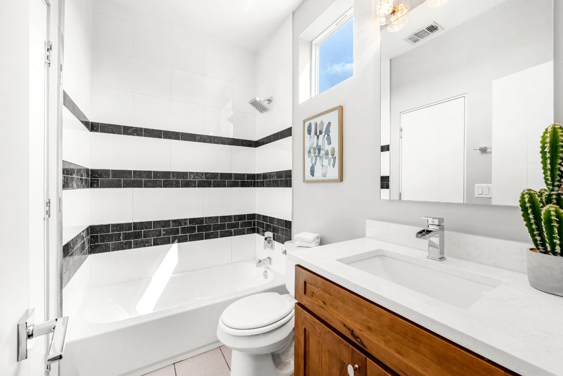 2203 East 51st Street, Unit A Austin, TX 78723 - Photo 20 of 25 a bathroom with a sink a toilet a mirror and shower