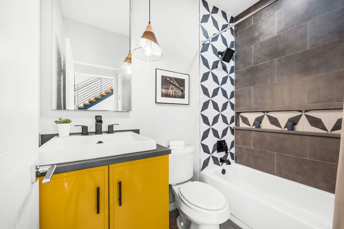 2203 East 51st Street, Unit A Austin, TX 78723 - Photo 8 of 25 a bathroom with a sink mirror vanity and toilet