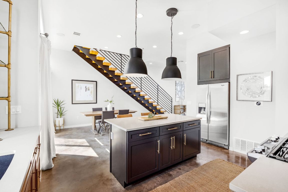 2203 East 51st Street, Unit A Austin, TX 78723 - Photo 10 of 25 a kitchen with stainless steel appliances kitchen island a large counter top and a wooden floor