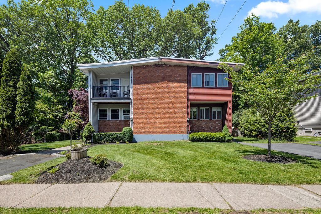 35 South Rigaud Road Spring Valley, NY 10977 - Photo 1 of 1 View of front of home featuring brick siding, a balcony, and a front lawn