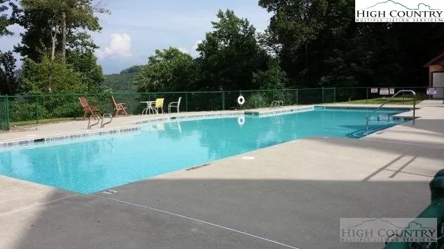 a view of a swimming pool with a yard and sitting area