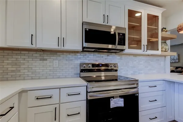 a kitchen with appliances a sink and cabinets
