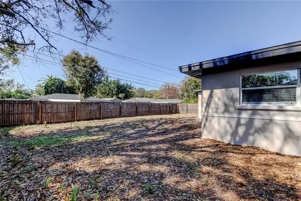 a view of backyard and wooden fence