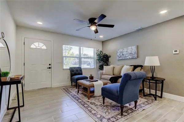 a living room with furniture a window and a ceiling fan