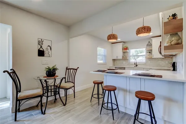 a kitchen with stainless steel appliances granite countertop a table and chairs in it