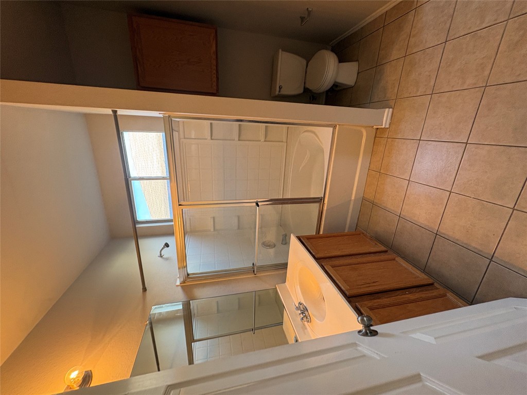 11510 Liberty Street Manor, TX 78653 - Photo 17 of 26 a bathroom with a granite countertop sink toilet and shower