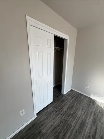 an empty room with wooden floor and closet