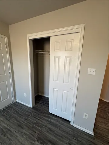 an empty room with wooden floor and closet