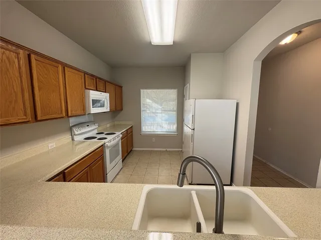 a kitchen with a refrigerator a stove a sink and a microwave