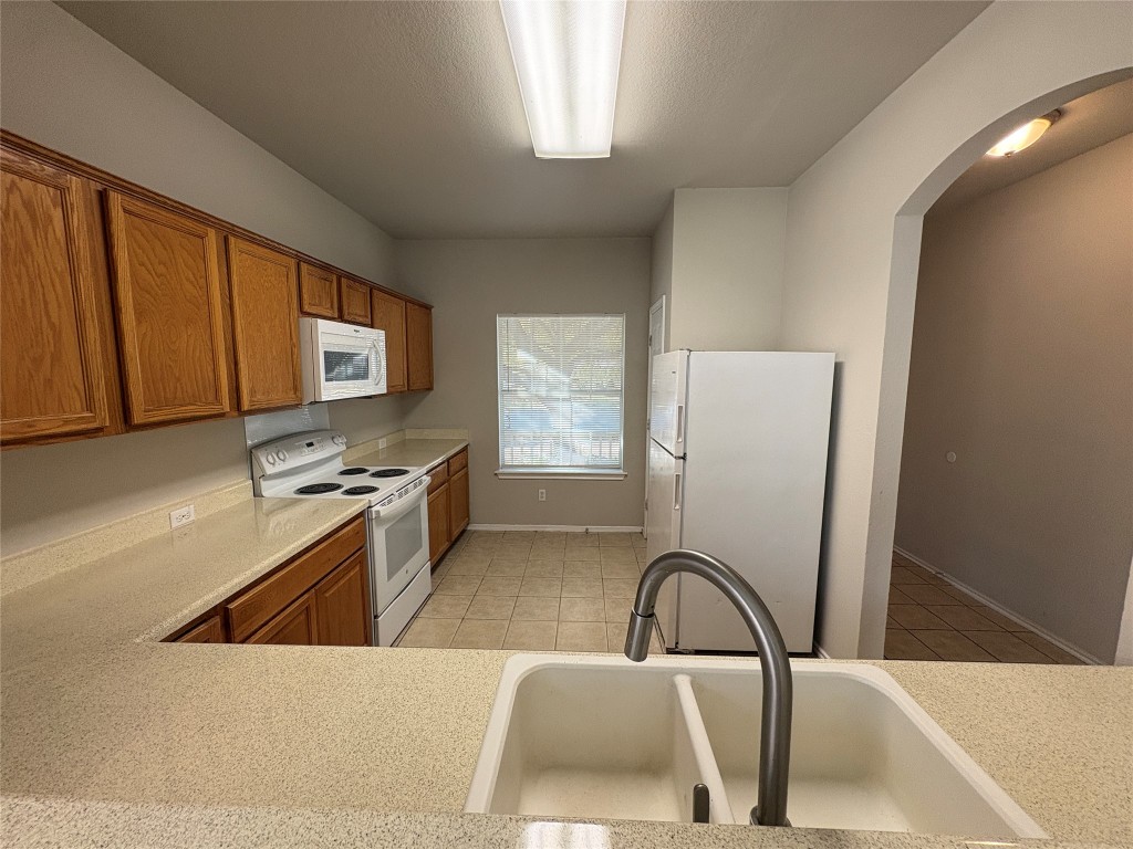 11510 Liberty Street Manor, TX 78653 - Photo 4 of 26 a kitchen with a refrigerator a stove a sink and a microwave