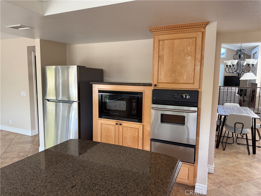 1030 Damascus Circle, Unit 1 Costa Mesa, CA 92626 - Photo 6 of 20 a kitchen with granite countertop a refrigerator stove and microwave