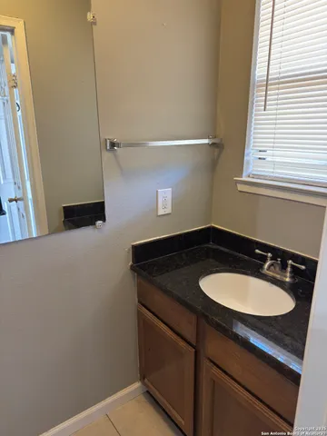 a bathroom with a granite countertop sink and a mirror