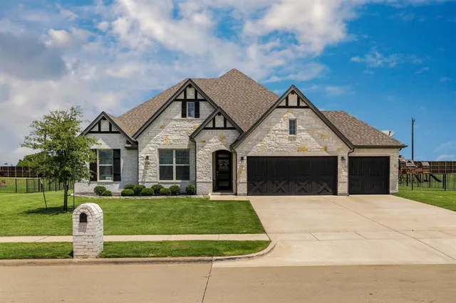 a front view of a house with a yard garage and trees