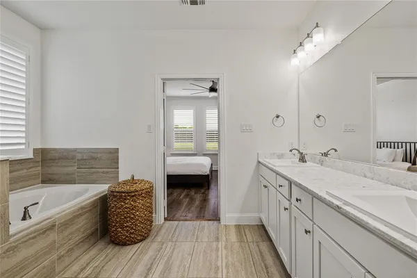 a bathroom with a granite countertop sink a mirror and a bathtub