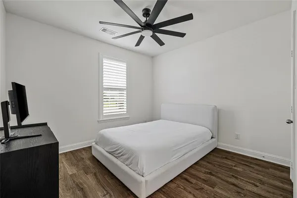 a bedroom with a bed and wooden floor