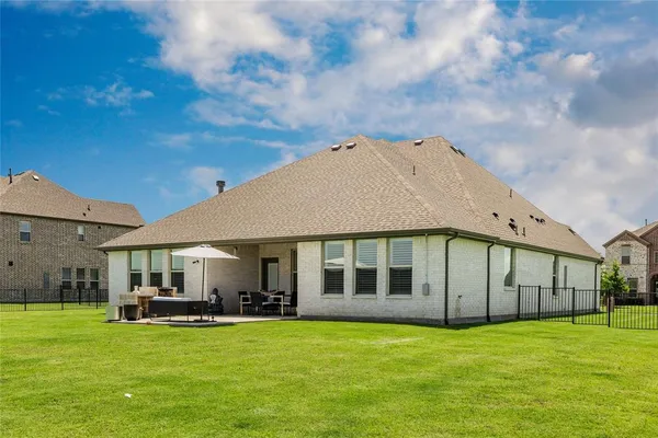 a view of a big house with a big yard and large trees