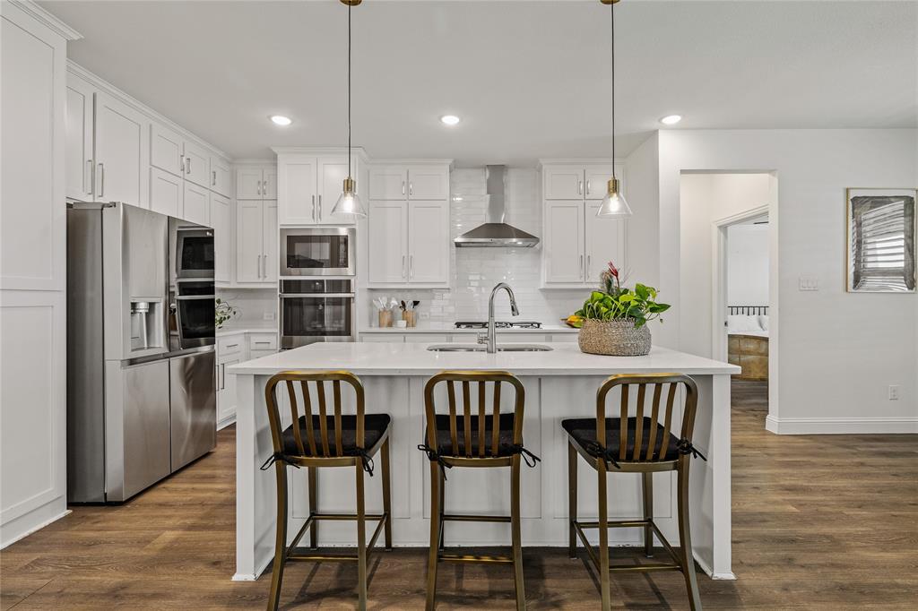 1430 Shaker Hills Road Gunter, TX 75058 - Photo 4 of 32 a kitchen with stainless steel appliances a dining table chairs refrigerator and microwave
