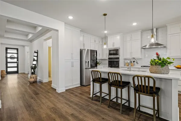 a view of kitchen with refrigerator and wooden floor
