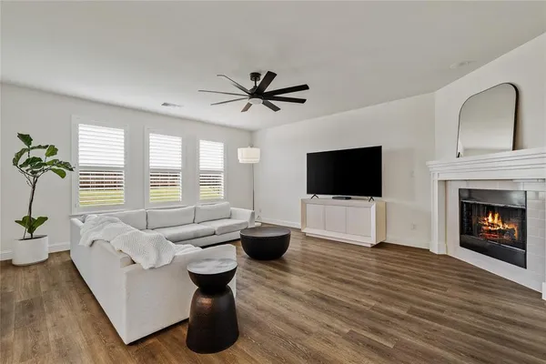 a living room with furniture a flat screen tv and a fireplace