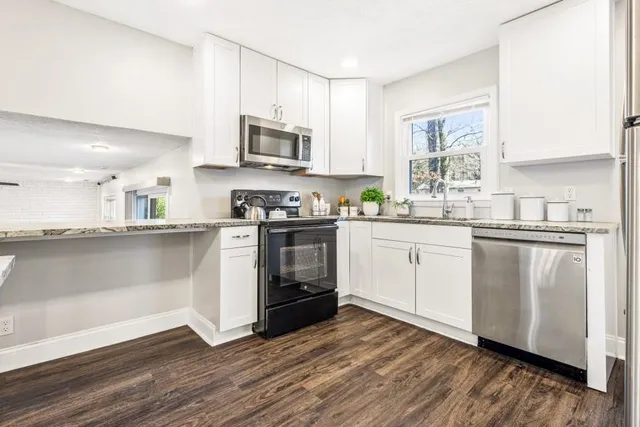 a kitchen with stainless steel appliances a white stove top oven sink and window
